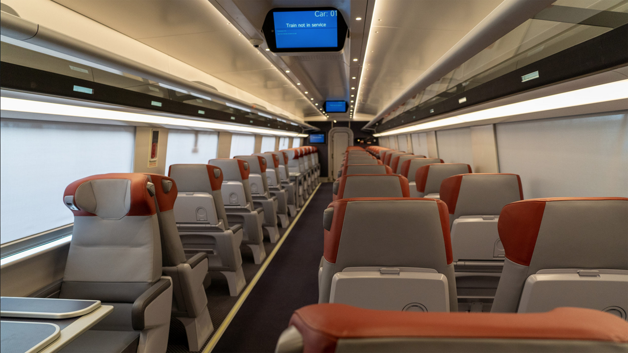 In the new Acela trainsets, the color “red” distinguishes First Class from Business Class—as evident in the headrests here, and also on the door to the trainset. These First Class seats provide more space and leg room as well as personal tray tables, according to Amtrak. (Photo Courtesy of Amtrak)